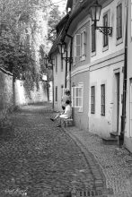 Women sitting in front of their house in a paved street in Prague