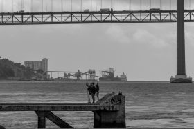 Family on a pier under the Ponte de 25 Abril, Lisbon