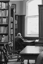 Reading older man in library in Belfast