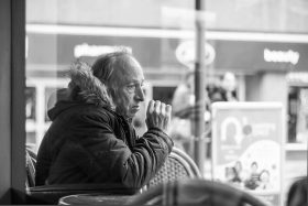 Sad older man in Belfast, smoking on terrace
