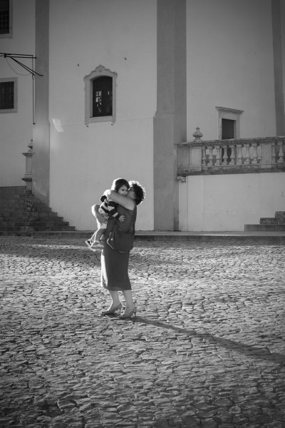 Grandmother embracing grandson on square in Sintra, Lisbon