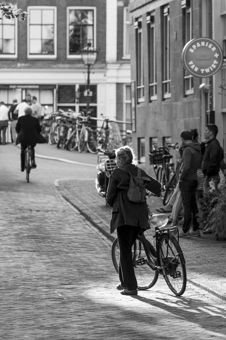 In the spotlight, older female cycler in Amsterdam